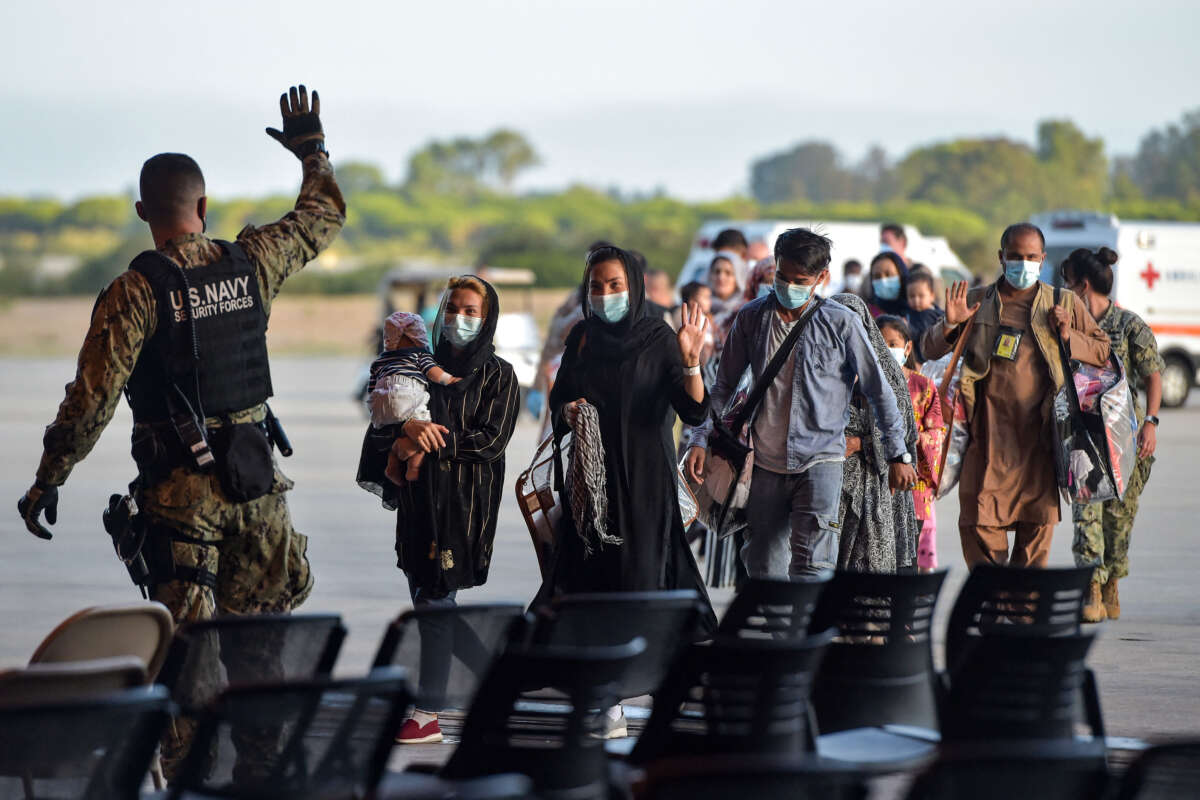 Refugees receive instructions from a U.S. Navy soldier as they disembark from a U.S. Air Force aircraft after an evacuation flight from Kabul at the Rota naval base in Rota, southern Spain, on August 31, 2021.