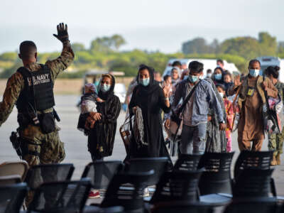 Refugees receive instructions from a U.S. Navy soldier as they disembark from a U.S. Air Force aircraft after an evacuation flight from Kabul at the Rota naval base in Rota, southern Spain, on August 31, 2021.