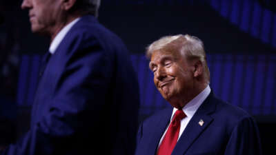 Robert F. Kennedy Jr. speaks on stage beside Republican presidential nominee Donald Trump during a campaign event at Desert Diamond Arena in Glendale, Arizona, on August 23, 2024.