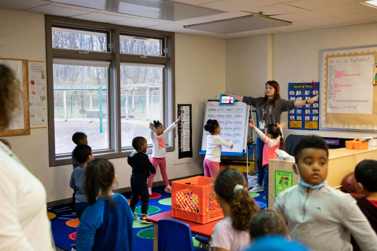 Young children, ages 3 to 5, participate in morning warm-up at the Head Start classroom, led by lead teacher Tanya Wetzel (right), on March 13, 2023, in Frederick, Maryland.