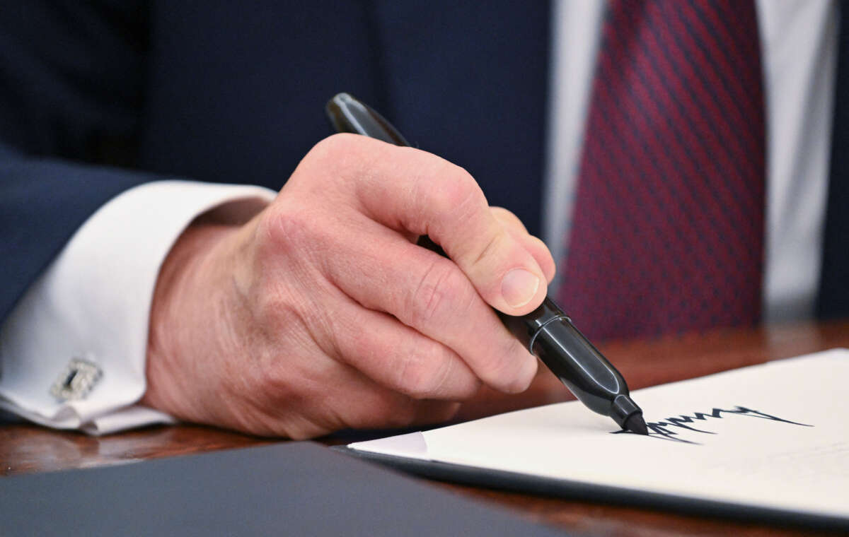 President Donald Trump signs an executive order in the Oval Office of the White House in Washington, D.C., on January 23, 2025.