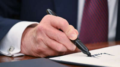 President Donald Trump signs an executive order in the Oval Office of the White House in Washington, D.C., on January 23, 2025.