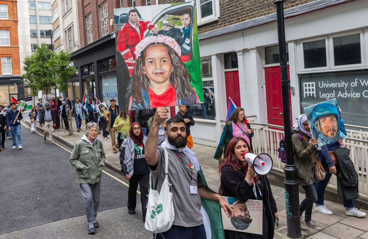 A demonstrator in solidarity with Palestinians holds up a painted image of Hind Rajab, a 6-year-old Palestinian girl killed in Gaza City in January 2024, and two Palestinian Red Crescent Society paramedics, before a national demonstration to mark the 76th anniversary of the Nakba on May 18, 2024 in London, United Kingdom.