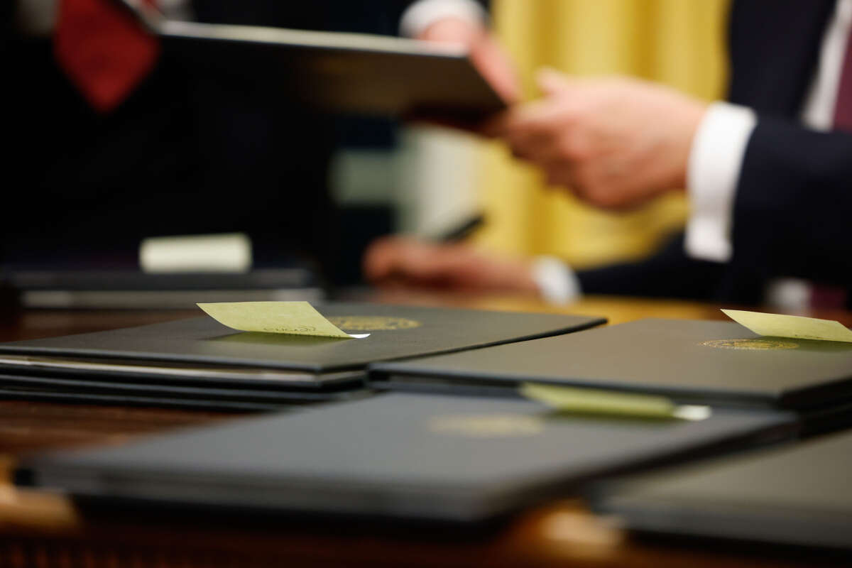 President Donald Trump signs executive orders in the Oval Office on January 20, 2025, in Washington, D.C.