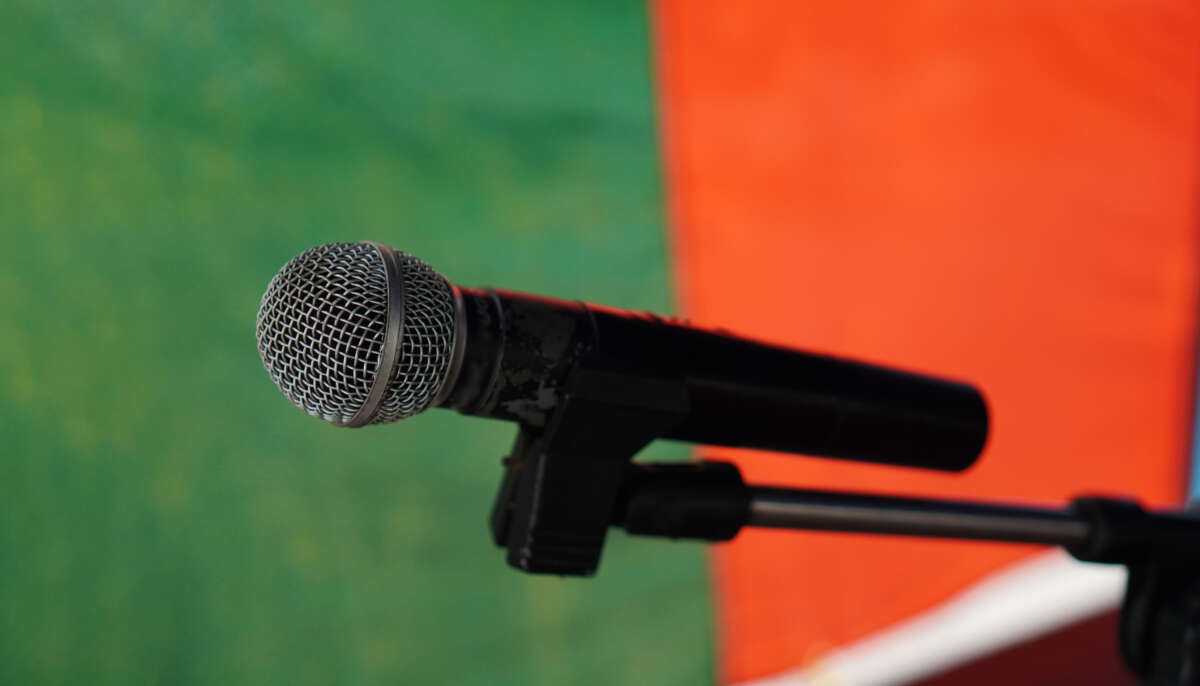 Microphone in front of green and red backdrop