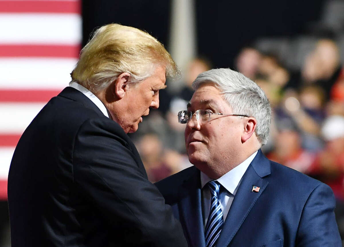 Donald Trump shakes hands with US senatorial candidate Patrick Morrisey (R) during a rally at WesBanco Arena in Wheeling, West Virginia on September 29, 2018.