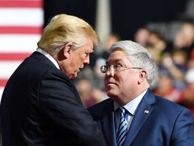 Donald Trump shakes hands with US senatorial candidate Patrick Morrisey (R) during a rally at WesBanco Arena in Wheeling, West Virginia on September 29, 2018.