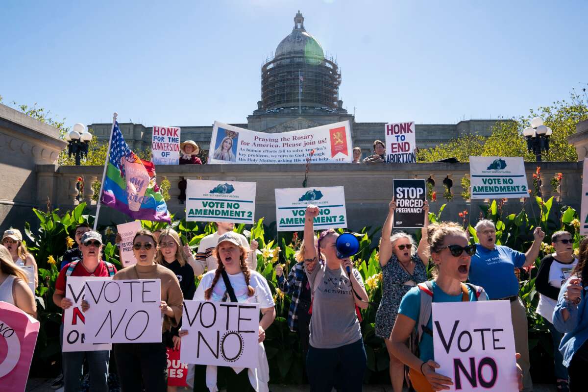 Counterprotesters hold signs encouraging voters to vote "no" on Amendment 2, which would add a permanent abortion ban to Kentucky's state constitution, on the steps of the capitol in Frankfort, Kentucky, on October 1, 2022.