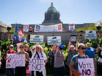 Counterprotesters hold signs encouraging voters to vote "no" on Amendment 2, which would add a permanent abortion ban to Kentucky's state constitution, on the steps of the capitol in Frankfort, Kentucky, on October 1, 2022.