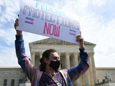 An activist holds a sign calling for federal protections of transgender rights, in front of the U.S. Supreme Court in Washington, D.C., on April 1, 2023.