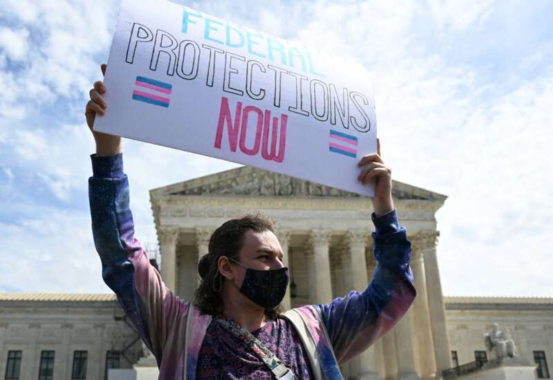 An activist holds a sign calling for federal protections of transgender rights, in front of the U.S. Supreme Court in Washington, D.C., on April 1, 2023.