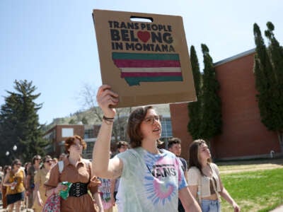 Transgender rights activists hold signs as they march through the University of Montana campus on May 03, 2023 in Missoula, Montana.