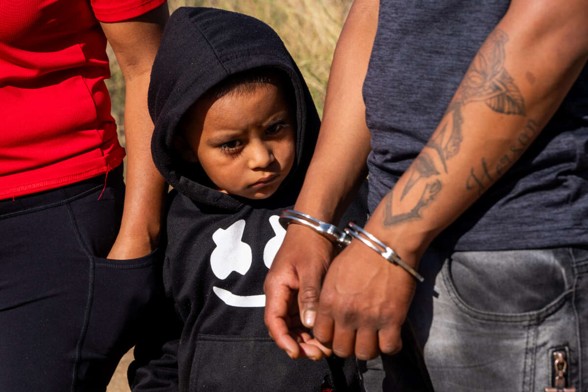 A child looks on as his father is arrested by U.S. Border Patrol agents on June 14, 2024, in Jacumba Hot Springs, California.