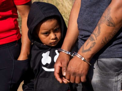 A child looks on as his father is arrested by U.S. Border Patrol agents on June 14, 2024, in Jacumba Hot Springs, California.