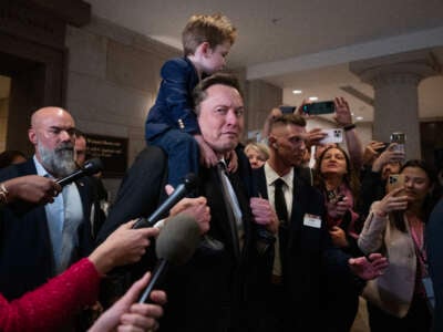 Elon Musk, with his son, makes his way to a meeting in the Capitol Visitor Center with House and Senate Republicans to talk about President-elect Donald Trump's "Department of Government Efficiency," on December 5, 2024, in Washington, D.C. Vivek Ramaswamy also attended.