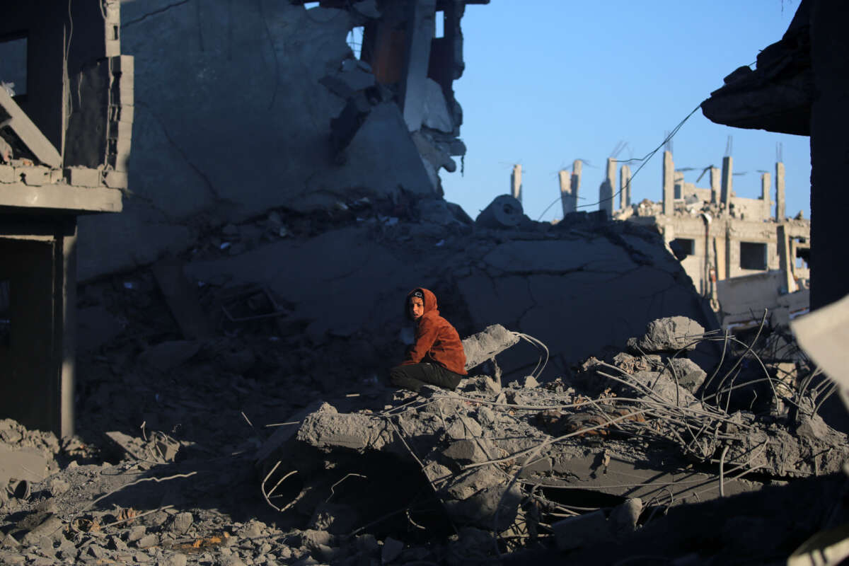 A young Palestinian boy sits amid the rubble in the aftermath of an Israeli strike in the al-Maghazi refugee camp in the central Gaza Strip, on January 3, 2025.