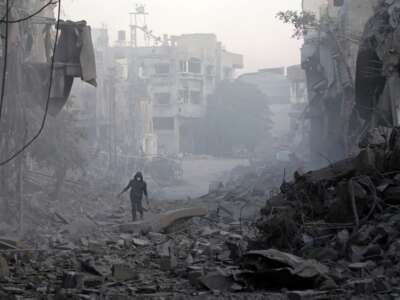 A man walks through the rubble of buildings destroyed by Israeli airstrikes at the Bureij camp for Palestinian refugees in the central Gaza Strip on January 12, 2025.