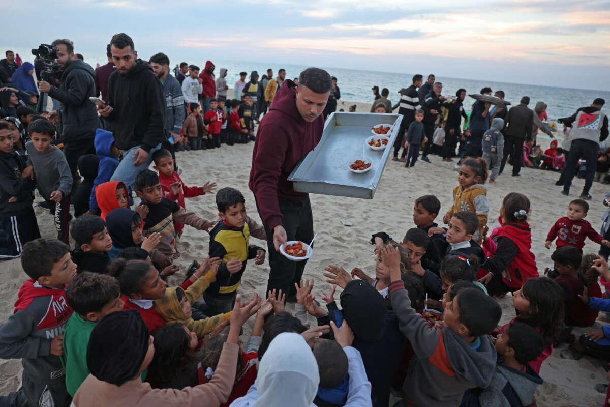 Hamada Shaqoura, a Palestinian man who used to be a food blogger, distributes food to children after cooking a meal for displaced people, in Khan Younis in the southern Gaza Strip on January 16, 2025.