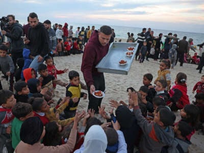 Hamada Shaqoura, a Palestinian man who used to be a food blogger, distributes food to children after cooking a meal for displaced people, in Khan Younis in the southern Gaza Strip on January 16, 2025.