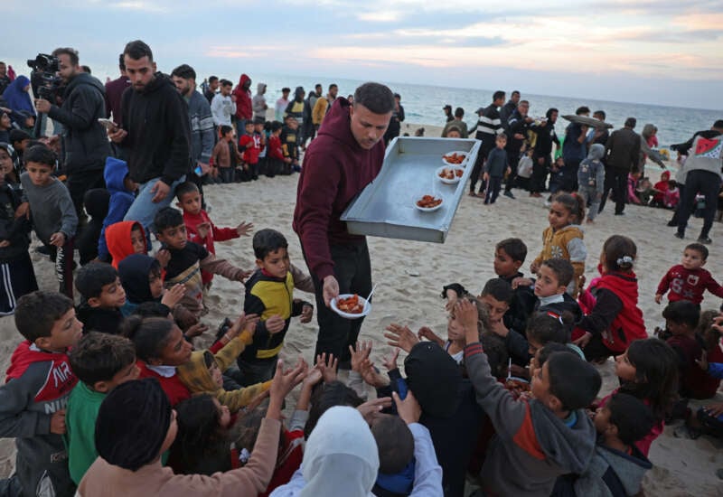 Hamada Shaqoura, a Palestinian man who used to be a food blogger, distributes food to children after cooking a meal for displaced people, in Khan Younis in the southern Gaza Strip on January 16, 2025.