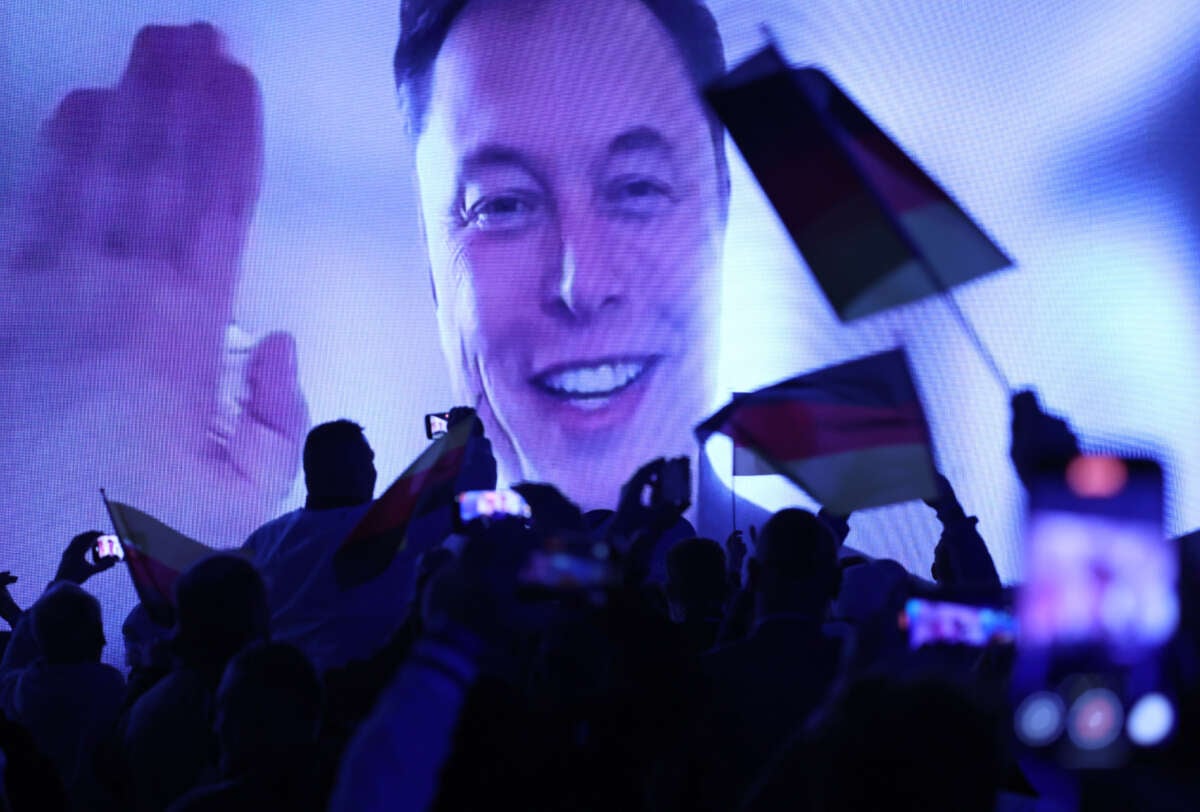 Tech billionaire Elon Musk speaks live via a video transmission during the election campaign launch rally of the far-right Alternative for Germany (AfD) political party as AfD supporters wave German flags on January 25, 2025, in Halle, Germany.