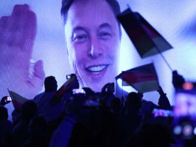 Tech billionaire Elon Musk speaks live via a video transmission during the election campaign launch rally of the far-right Alternative for Germany (AfD) political party as AfD supporters wave German flags on January 25, 2025, in Halle, Germany.