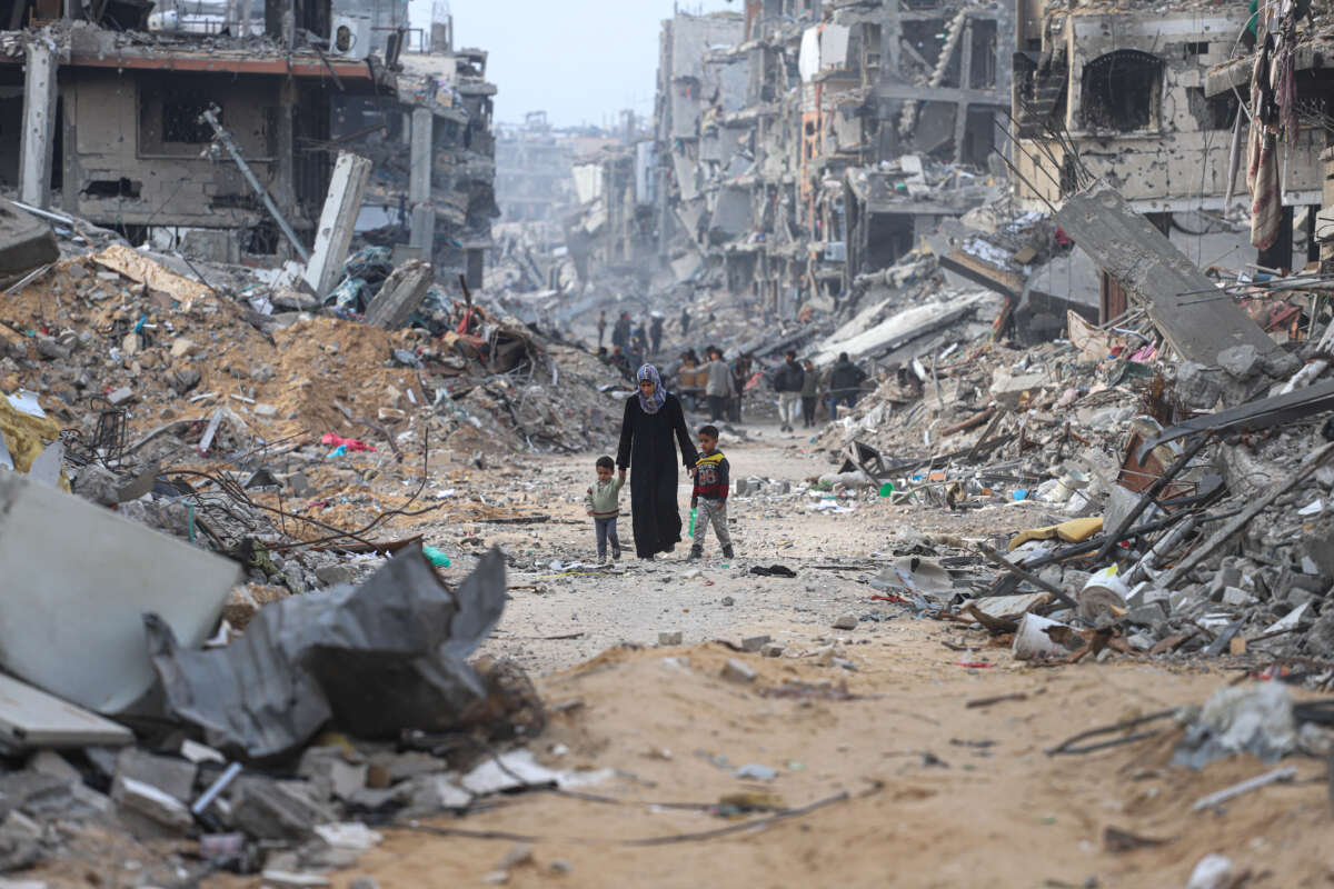 A woman walks along a path through rubble with her children as displaced Palestinians return to northern Gaza to live in tents built on the ruins of their homes, on January 28, 2025, in Gaza, Palestine.