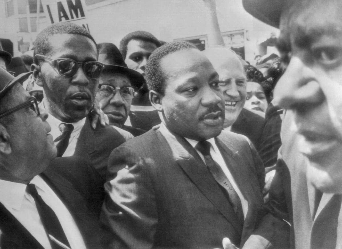 Dr. Martin Luther King is surrounded by leaders of the sanitation strike in Memphis, Tennessee, as he arrives to lead a march in support of the striking workers on March 28, 1968.