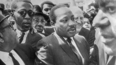 Dr. Martin Luther King is surrounded by leaders of the sanitation strike in Memphis, Tennessee, as he arrives to lead a march in support of the striking workers on March 28, 1968.