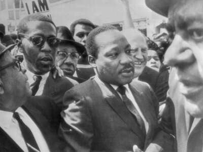 Dr. Martin Luther King is surrounded by leaders of the sanitation strike in Memphis, Tennessee, as he arrives to lead a march in support of the striking workers on March 28, 1968.