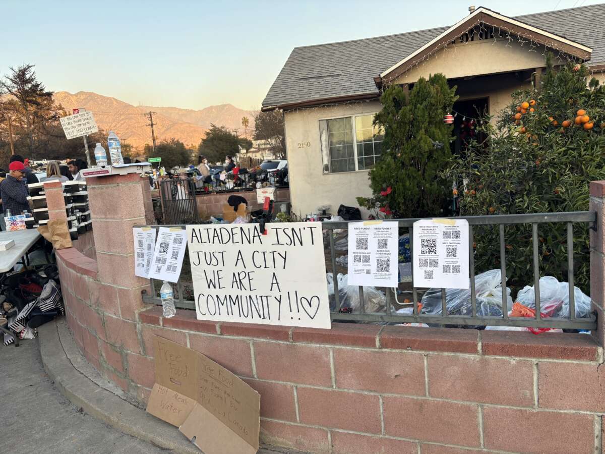 A mutual aid hub sits on the border between North Pasadena and Altadena at the corner of Woodbury Avenue and Glenrose Street, next to a home destroyed by the Eaton Fire.