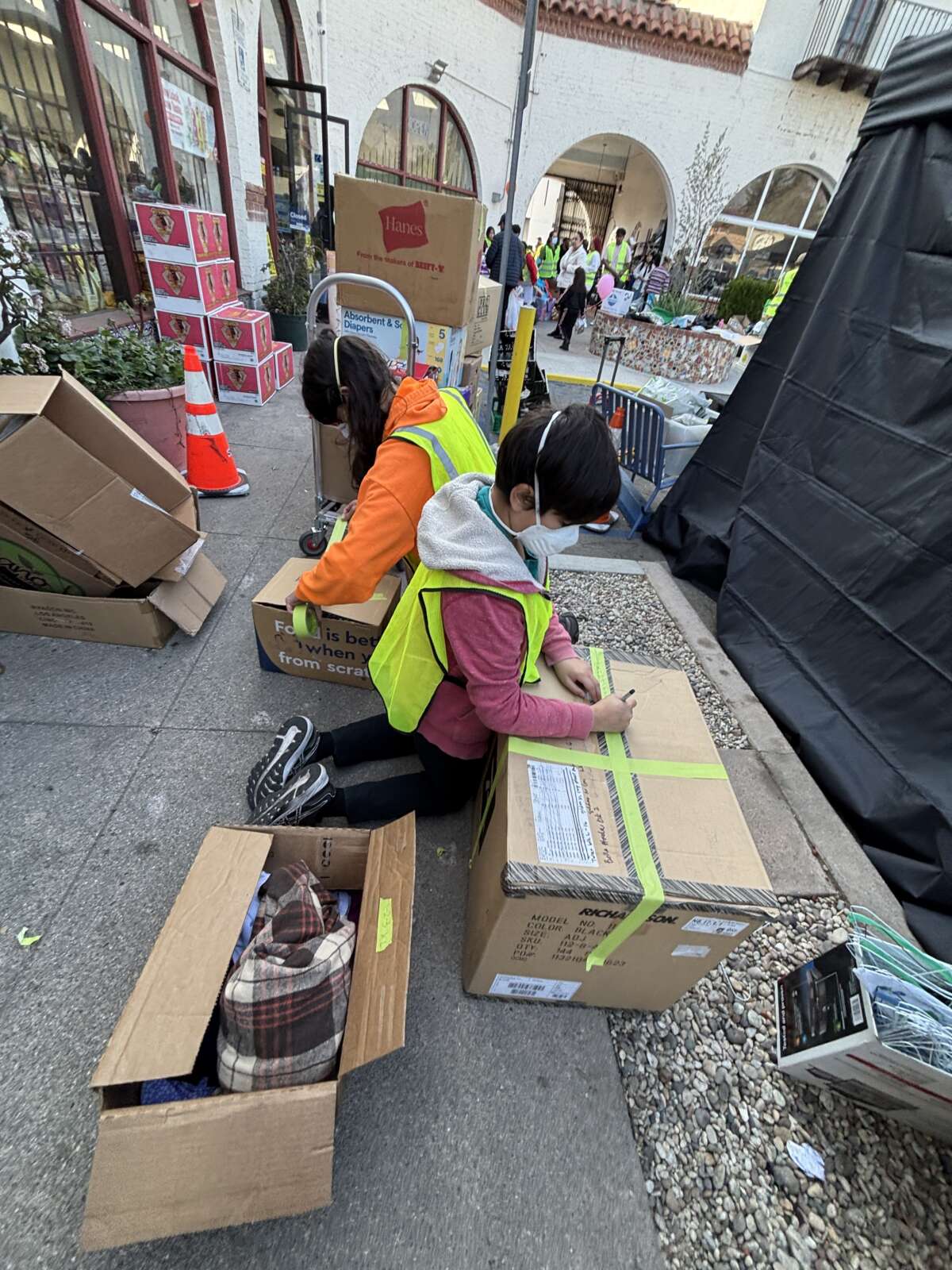 Sonali’s son’s Neal Kolhatkar and Naveen Ingalls sort clothing donations at a mutual aid hub at Hen’s Teeth Square on the border of North Pasadena and Altadena on January 19, 2025.