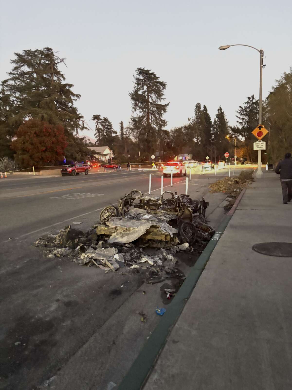 A burned car sits on Woodbury Avenue on the border between North Pasadena and Altadena.