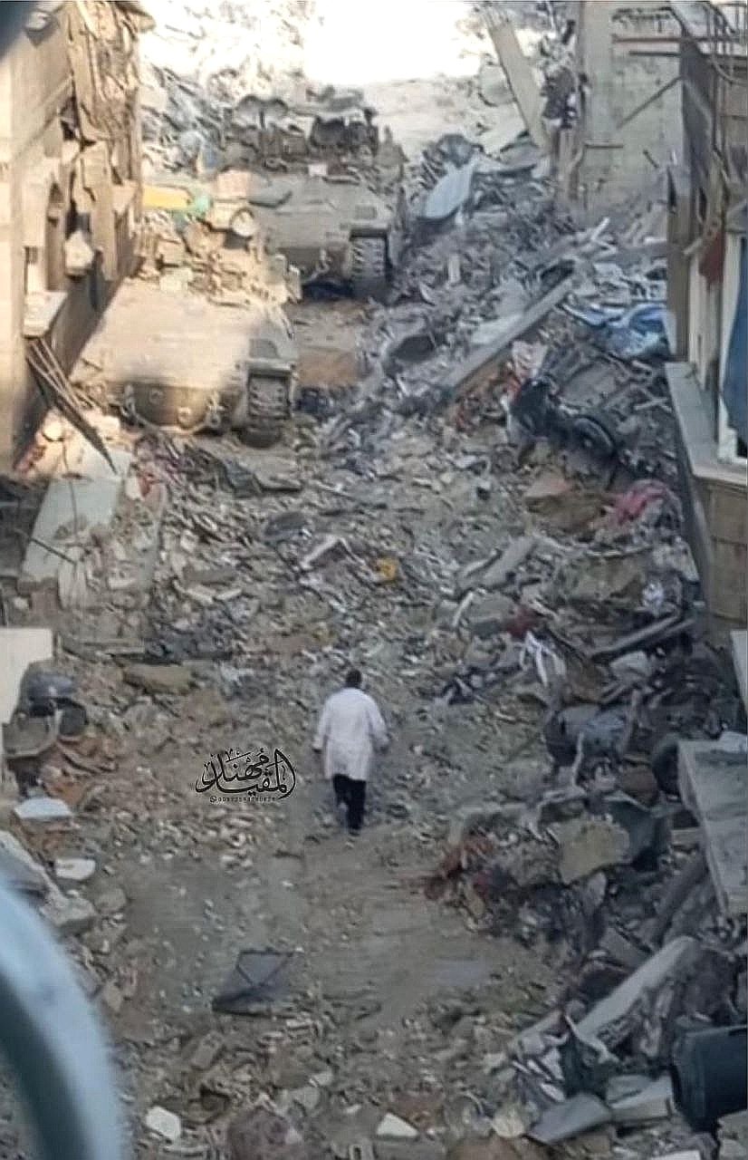 A photo of Dr. Hussam Abu Safiya that went viral on social media, showing him in his white coat walking amidst the rubble towards Israeli tanks surrounding the Kamal Adwan Hospital in Beita Lahia in northern Gaza. Photo via X.