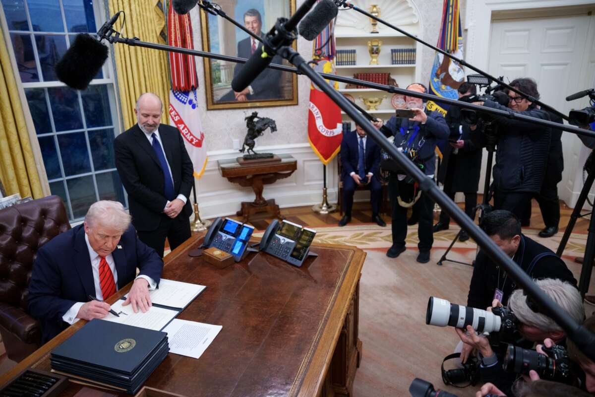 President Donald Trump, joined by Commerce Secretary nominee Howard Lutnick, signs a series of executive orders.