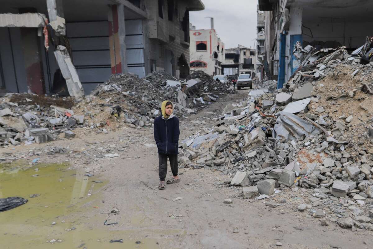 A young boy walks alone through a street filled with rubble and debris, in Gaza City on February 10, 2025.