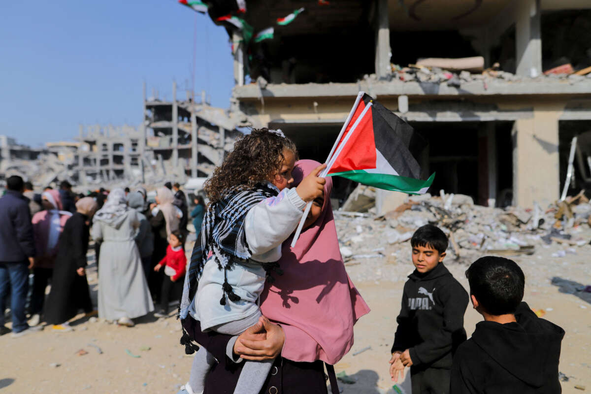 A woman holds a child near the rubble of destroyed buildings in Gaza Strip on January 30, 2025.