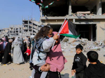 A woman holds a child near the rubble of destroyed buildings in Gaza Strip on January 30, 2025.