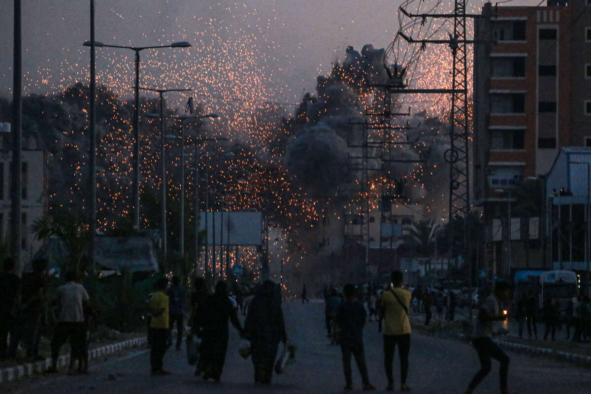 Palestinians watch smoke billowing following an Israeli airstrike in Deir al-Balah in the central Gaza Strip on June 6, 2024, amid the ongoing conflict between Israel and the Palestinian militant group Hamas.