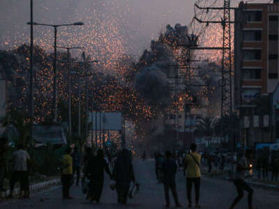 Palestinians watch smoke billowing following an Israeli airstrike in Deir al-Balah in the central Gaza Strip on June 6, 2024, amid the ongoing conflict between Israel and the Palestinian militant group Hamas.