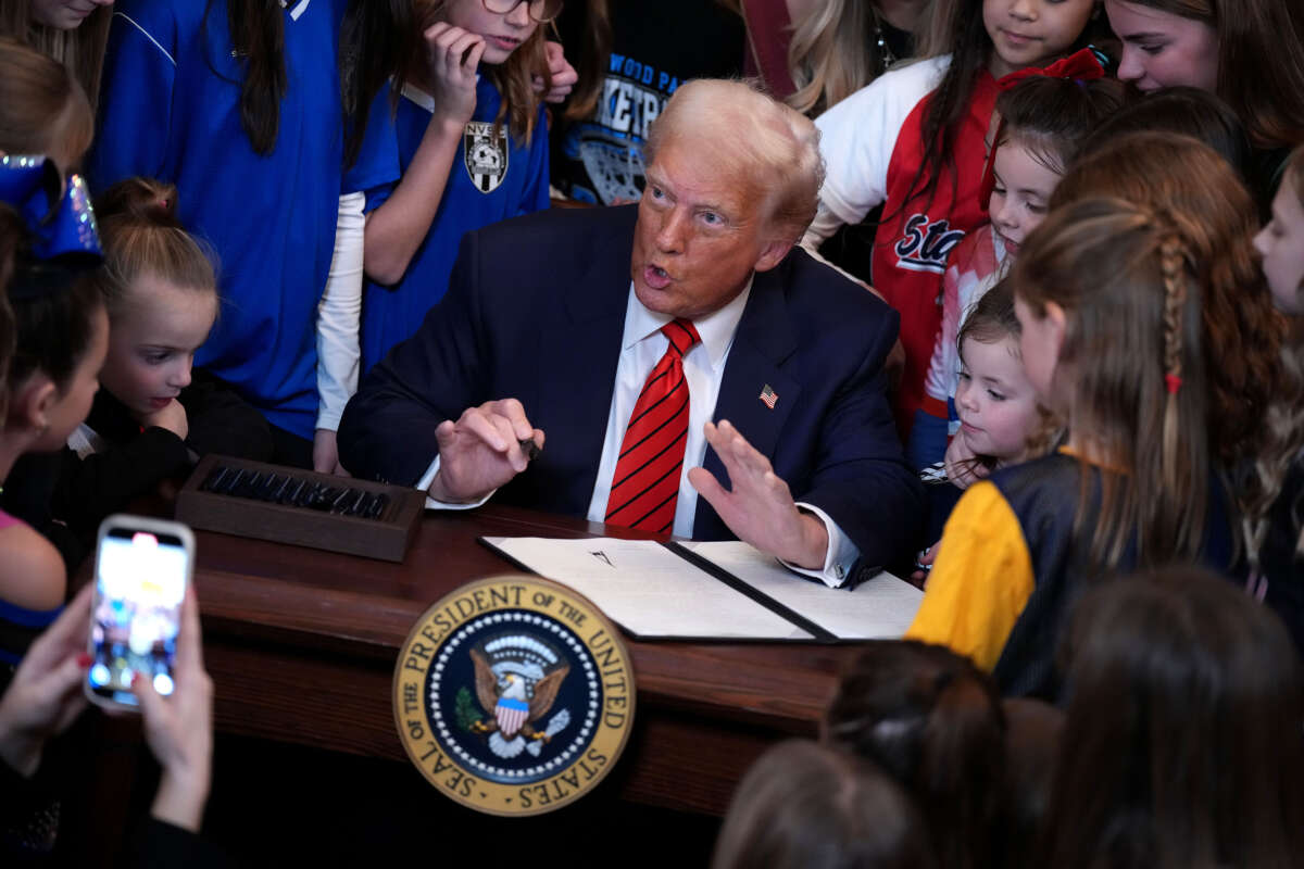 President Donald Trump, joined by child athletes, signs an executive order banning trans women and girls from women's sports, in the East Room at the White House on February 5, 2025, in Washington, D.C.