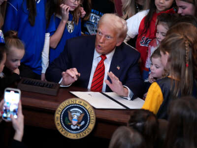 President Donald Trump, joined by child athletes, signs an executive order banning trans women and girls from women's sports, in the East Room at the White House on February 5, 2025, in Washington, D.C.