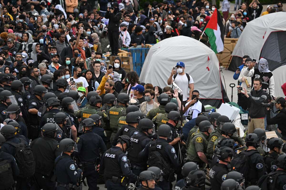 Pro-Palestinian demonstrators clash with police as they clear an encampment after students occupied the Physical Sciences Lecture Hall at the University of California, Irvine, in Irvine, California, on May 15, 2025.