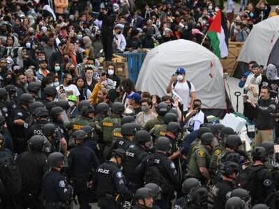 Pro-Palestinian demonstrators clash with police as they clear an encampment after students occupied the Physical Sciences Lecture Hall at the University of California, Irvine, in Irvine, California, on May 15, 2025.