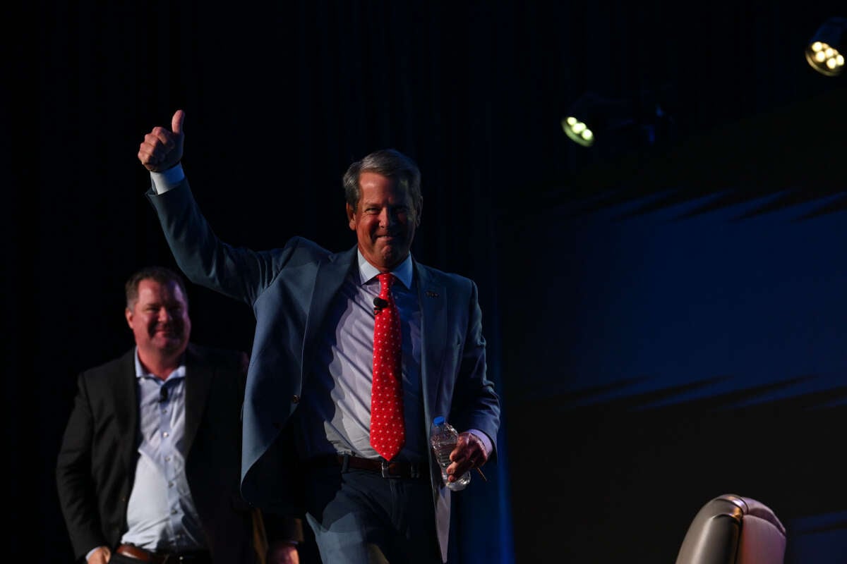 Georgia Gov. Brian Kemp gives the thumbs down to as he exits the stage after speaking during The Gathering conservative conference hosted and moderated by talk radio host Erick Erickson (left) at the Grand Hyatt hotel on August 18, 2023, in Atlanta, Georgia.