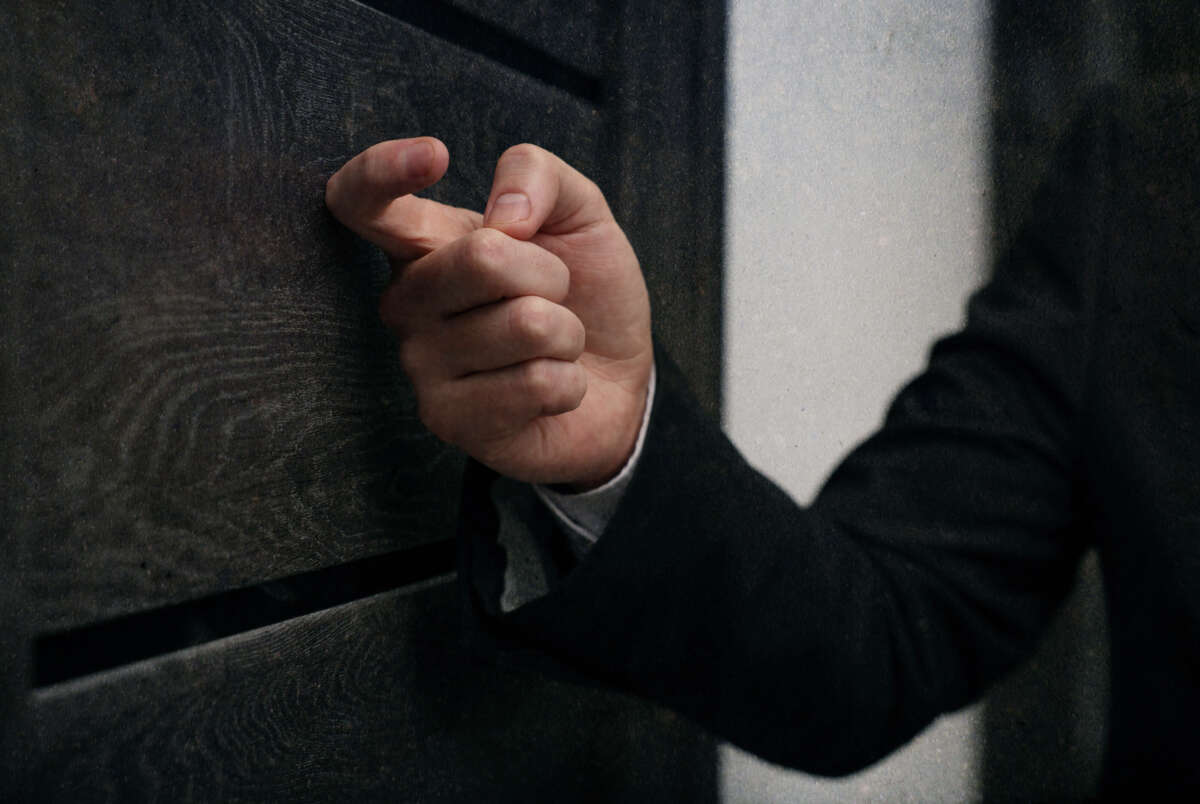 Hand of a man in a suit knocks on a door