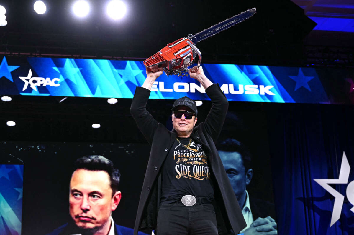 Elon Musk holds a chainsaw reading 'Long live freedom, damn it' during the annual Conservative Political Action Conference (CPAC) at the Gaylord National Resort & Convention Center at National Harbor in Oxon Hill, Maryland, on February 20, 2025.