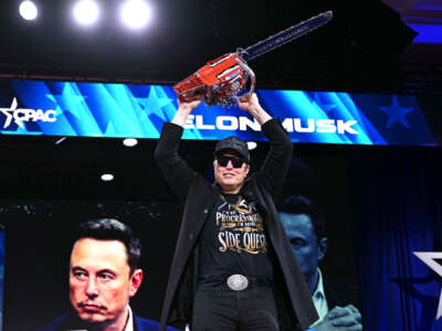 Elon Musk holds a chainsaw reading 'Long live freedom, damn it' during the annual Conservative Political Action Conference (CPAC) at the Gaylord National Resort & Convention Center at National Harbor in Oxon Hill, Maryland, on February 20, 2025.