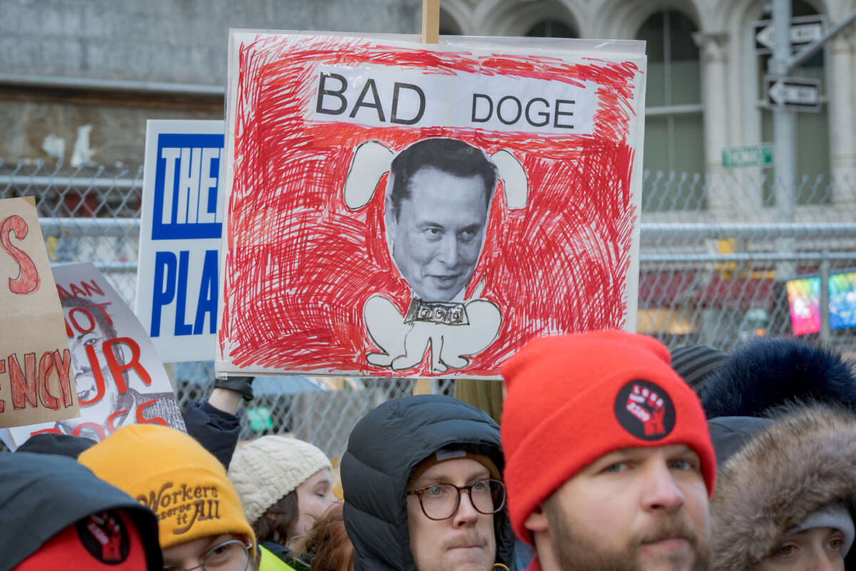 A sign reading Bad DOGE with Elon Musk's face over an illustration of a dog is seen at a protest against Elon Musk's DOGE efforts