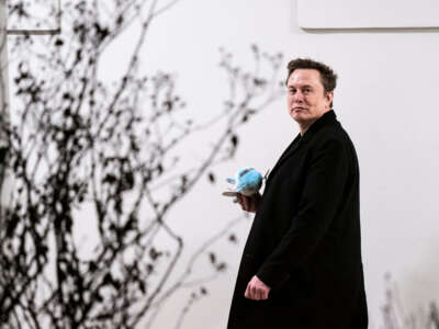 Elon Musk carries a stuffed Air Force One as he walks back to the West Wing along the colonnade after returning to the White House on Marine One on February 19, 2025, in Washington, D.C.